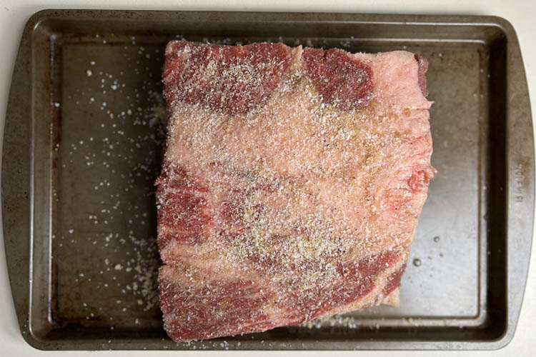 raw beef belly with cure on a steel tray