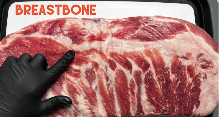 rack of ribs with finger in black glove showing where the breastbone is