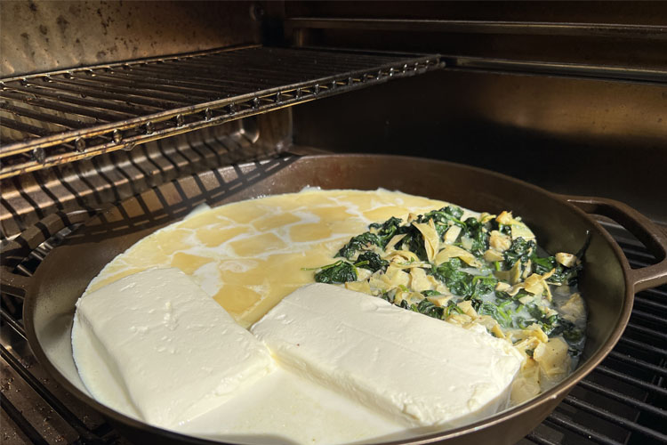 cheese melting in cast iron pan in the grill
