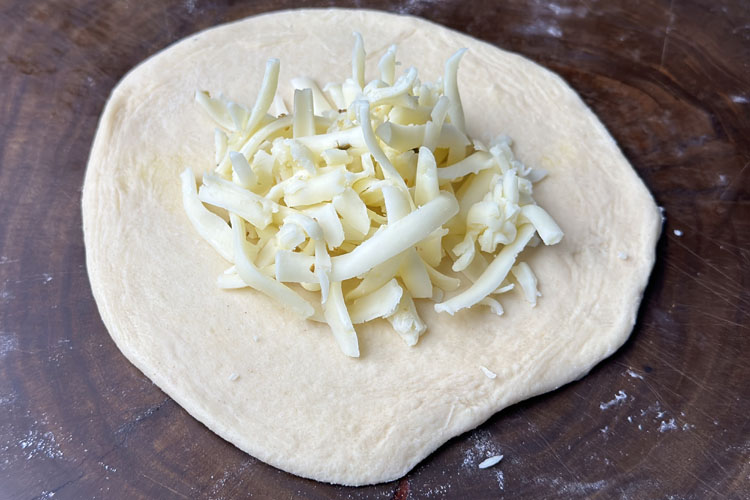 a rolled biscuit with cheddar cheese on top