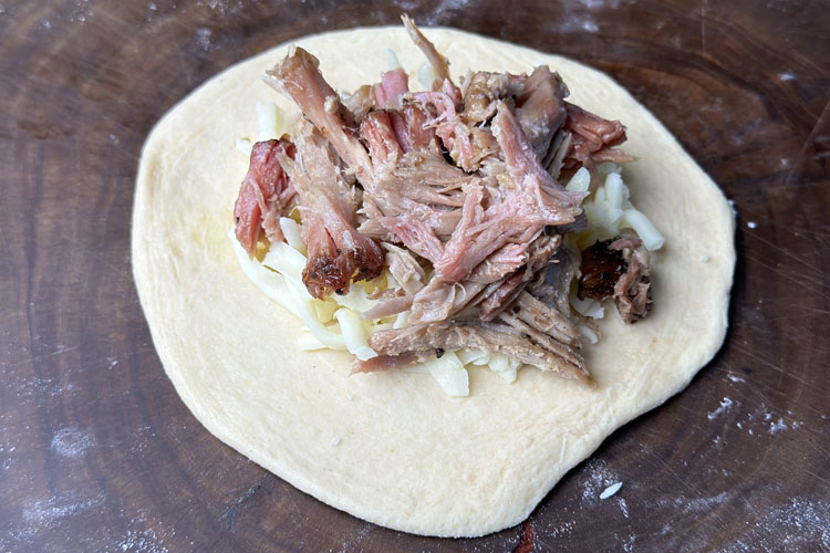 rolled biscuit with cheese and pulled pork on top