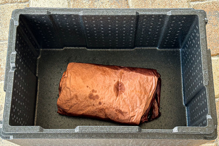 brisket wrapped in butcher paper in a cambro