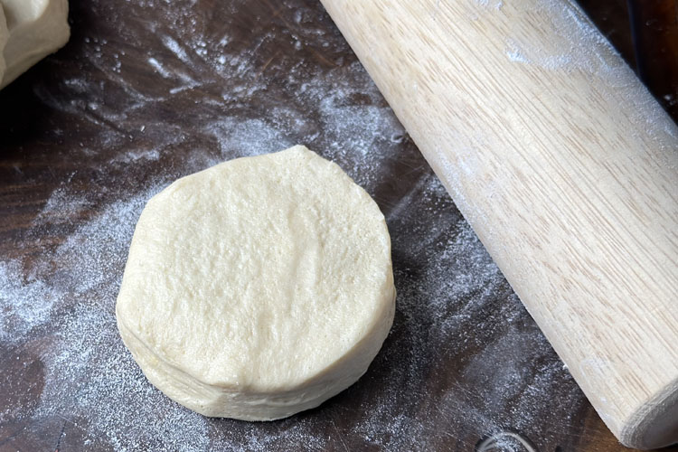 a raw biscuit and a rolling pin