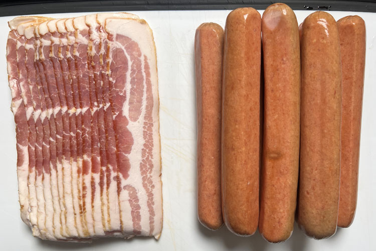 a slab of bacon and a pile of hot dogs