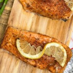 grilled salmon fillets served on a cedar plank and garnished with lemon slices