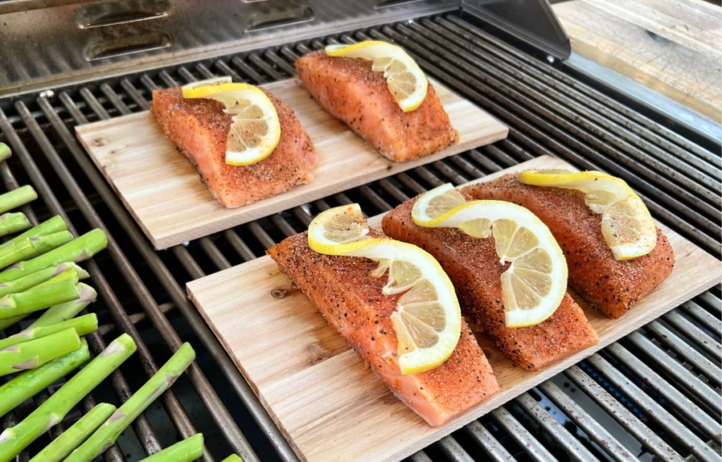 cedar plank salmon on the grill with asparagus beside it