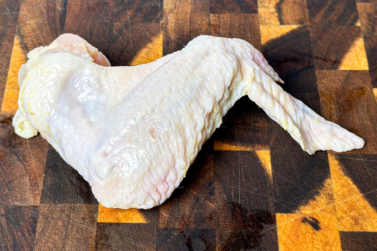 wing stretch out on wooden chopping board