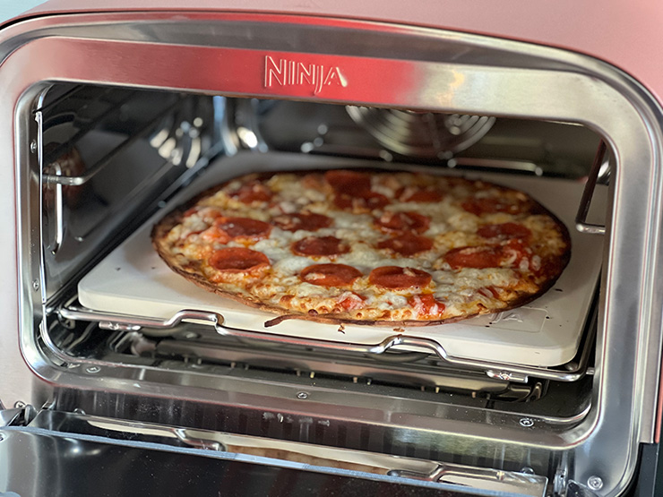 cooked pizza inside the Ninja Woodfire Outdoor Oven