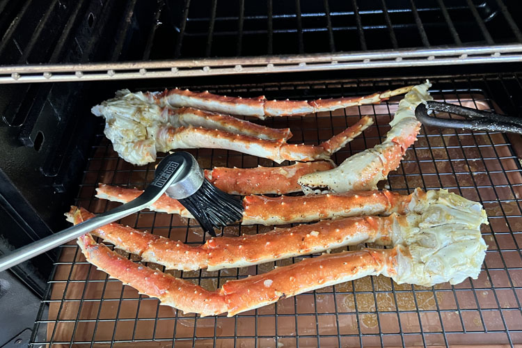 a brush basting the crab legs