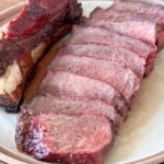 sliced grilled Delmonico steak on a light color plate
