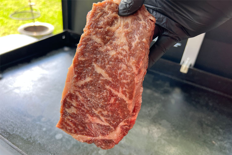 american wagyu being held in the air