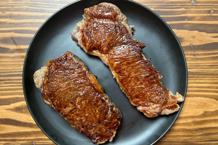cooked wagyu on a black plate