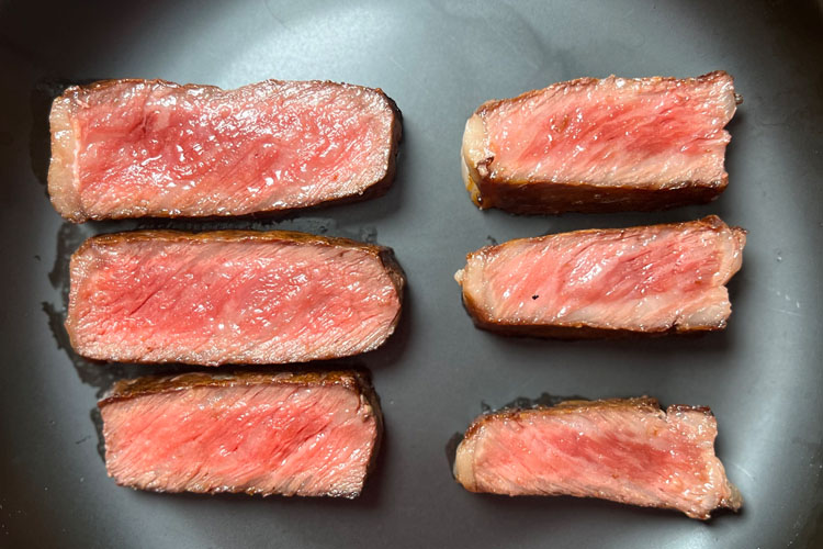 slices of waygu on black plate