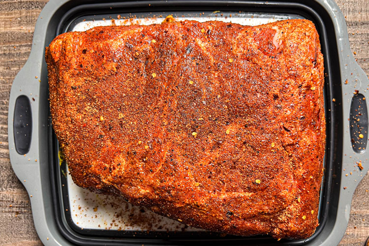 raw pork butt covered in bbq rub
