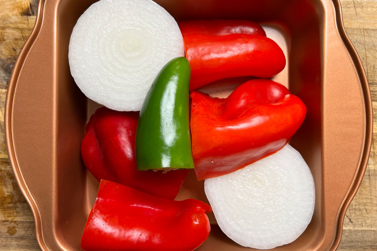 jalapeno, white onion, bell pepper chopped in a roasting pan