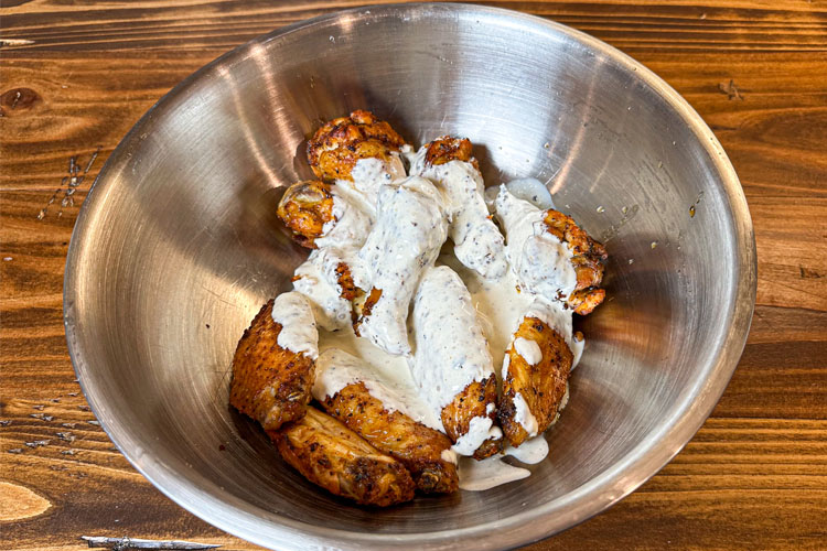 wings in a bowl with alabama white sauce