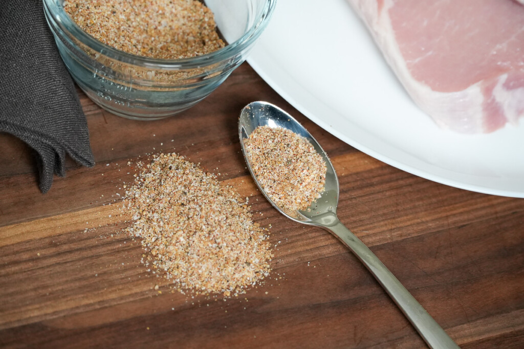 pork seasoning on a wooden board and a tablespoon