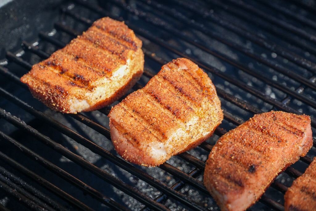 3 pork chops on the smoker with nice griddle marks on them