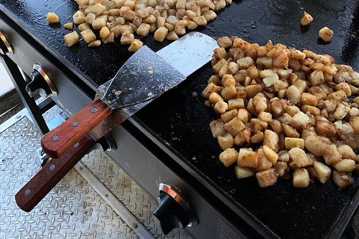 two griddle spatulas on a flat top grill
