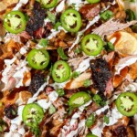 redneck nachos with various toppings in a foil tray