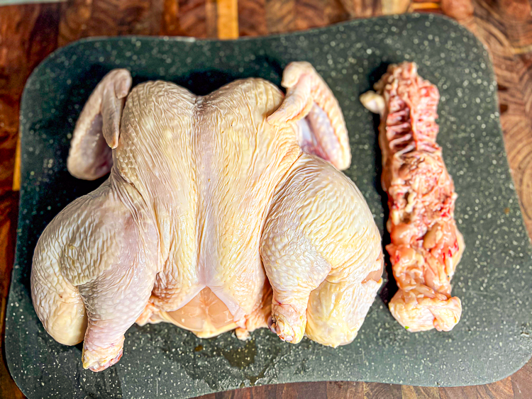 a spatchcocked chickent with the backbone besdie it