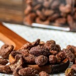a wooden spoon full of smoked candied nuts