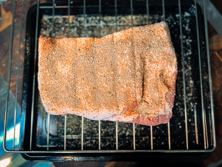 seasoned piece of pork belly on a wire rack