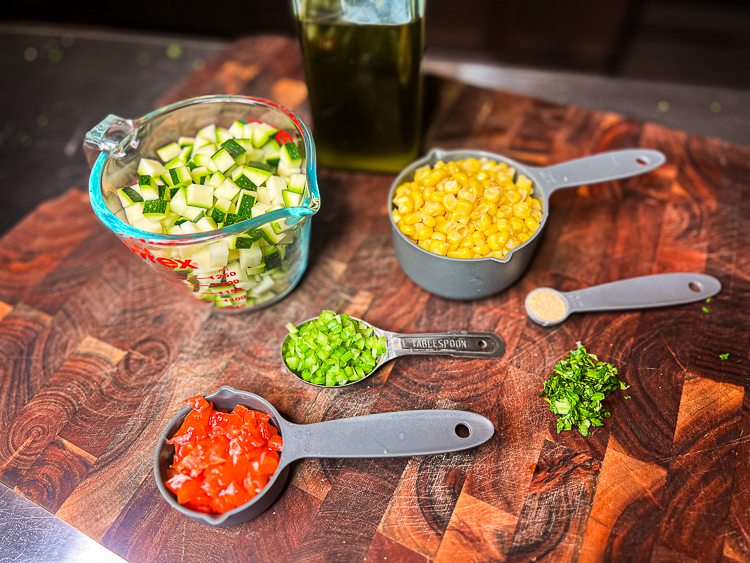 Zucchini corn succotashingredients laid out on a wooden board