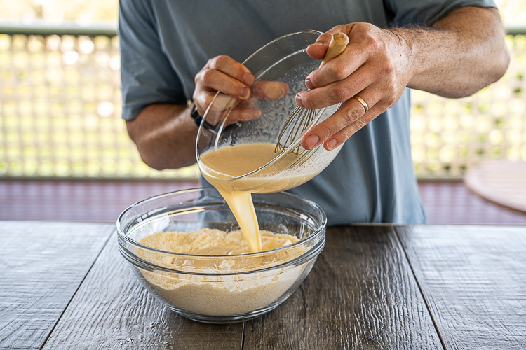 pouring wet ingredients into dry for cornbread