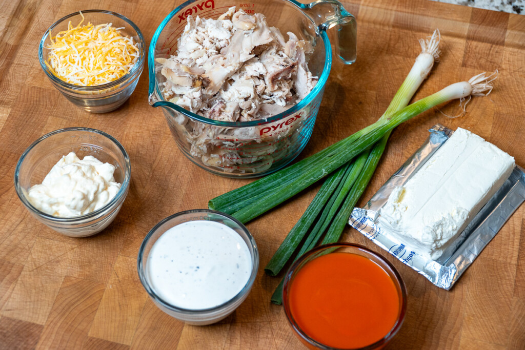 smoked buffalo cheese dip ingredients on a wooden chopping board
