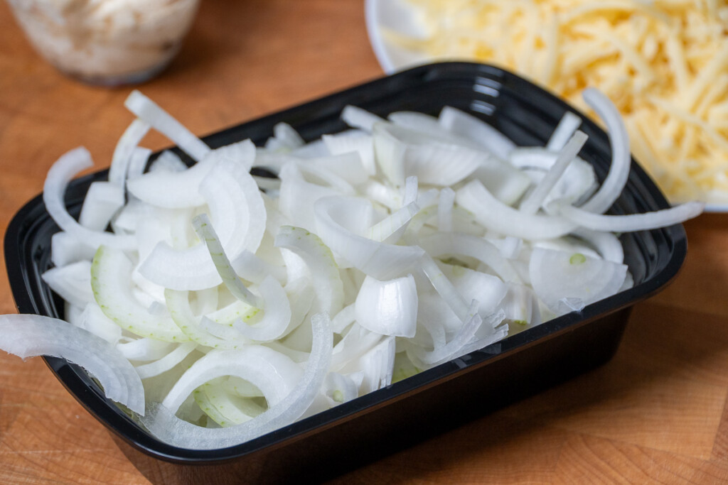 sliced onions in a black casserole dish