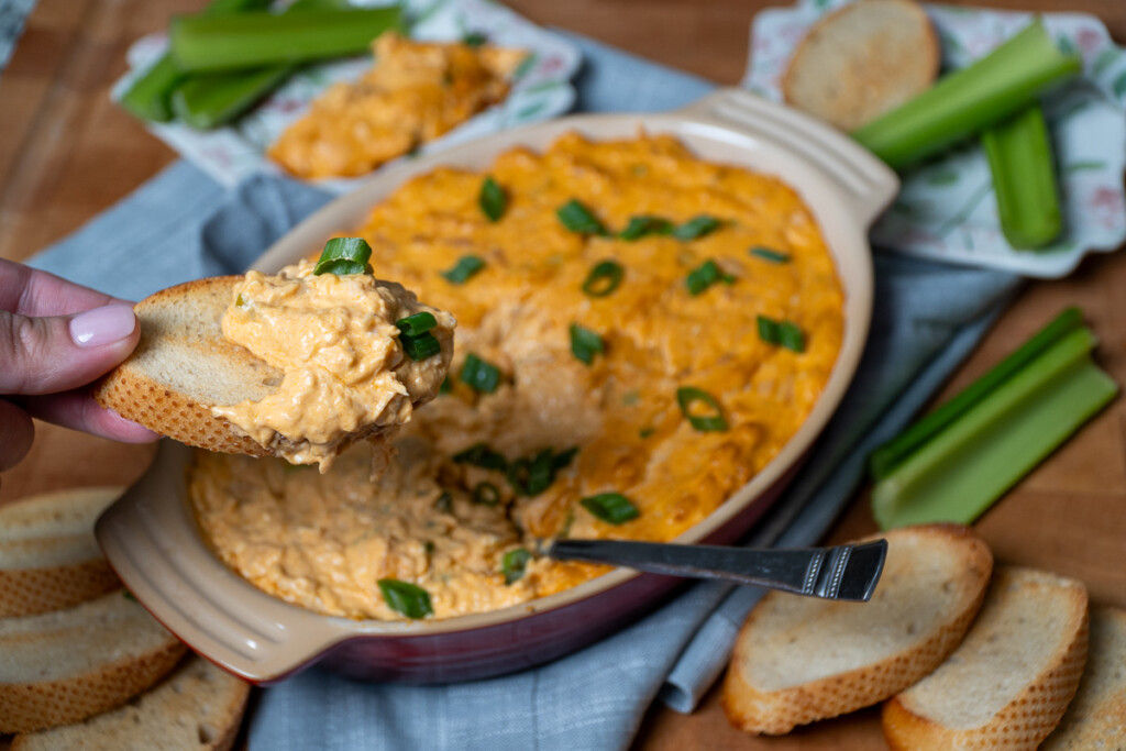a piece of French bread with smoked buffalo chicken dip on it