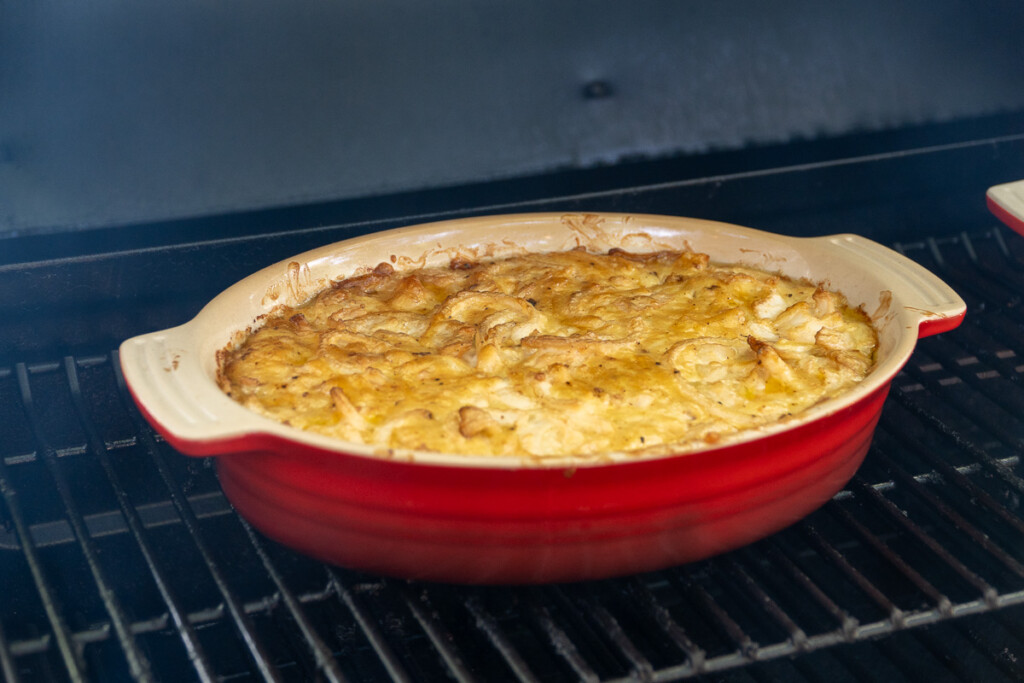 smoked onion dip in a red casserole dish in the smoker at the end of the cook