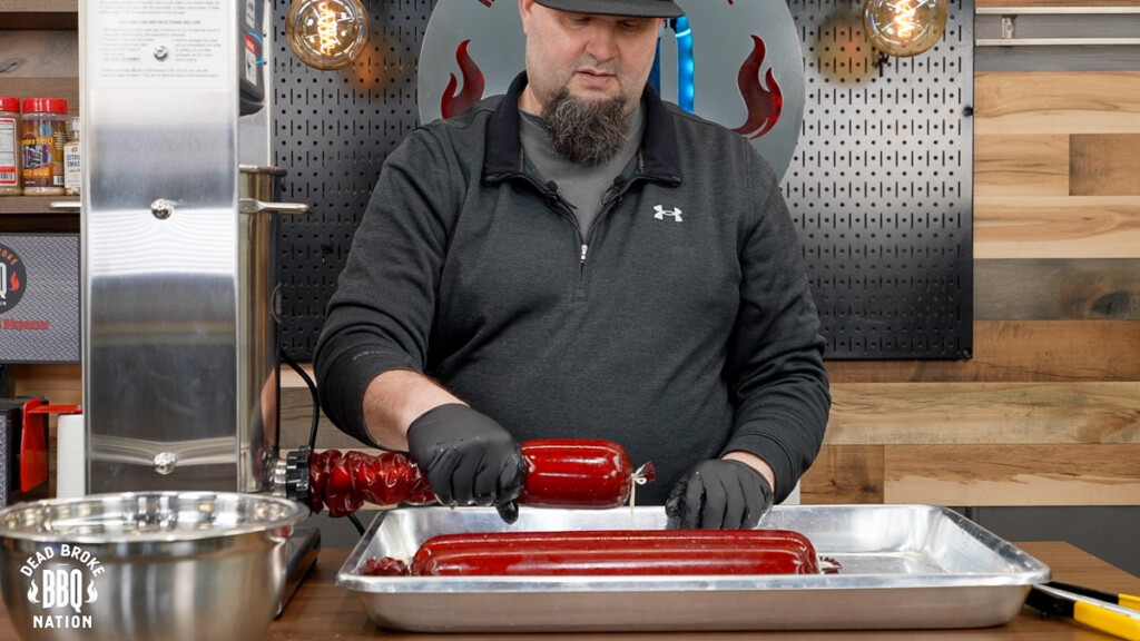 a man stuffing a summer sausage