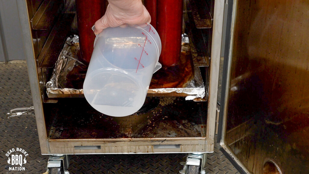water in a bucket being added to the smoker