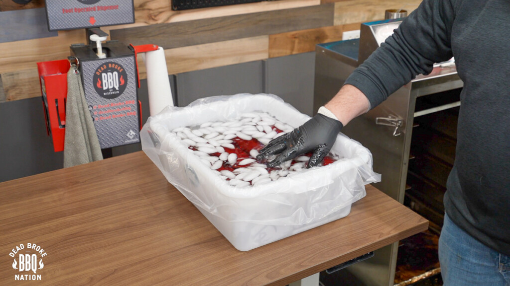 a white tub ice bath with smoked summer sausage in it