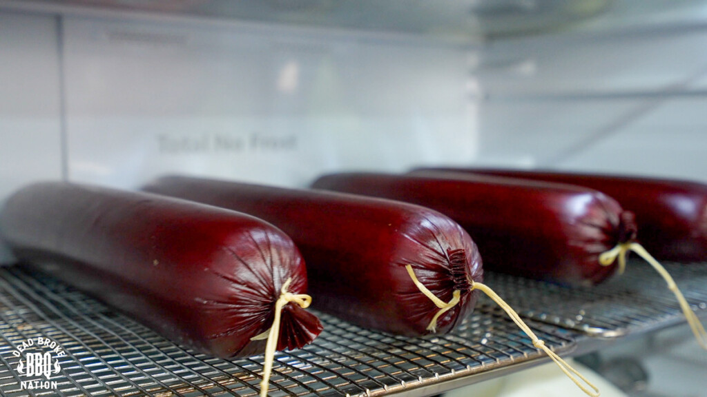 summer sausages on a wire rack in the fridge