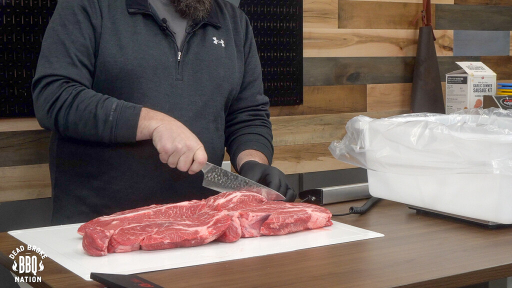 slabs of meat on a white board being cut up