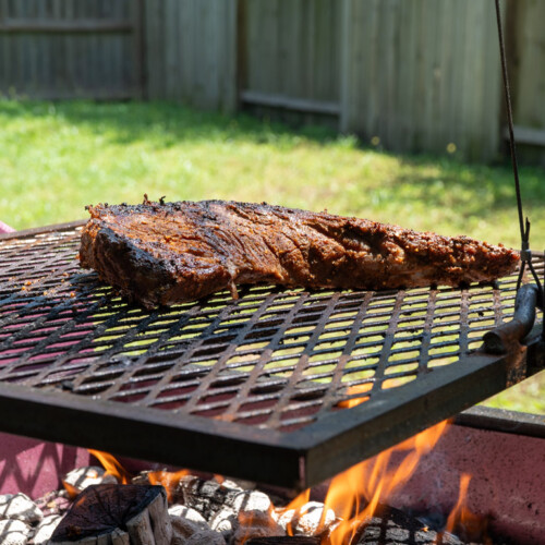 tri-tip on the Santa maria grill with flames underneath