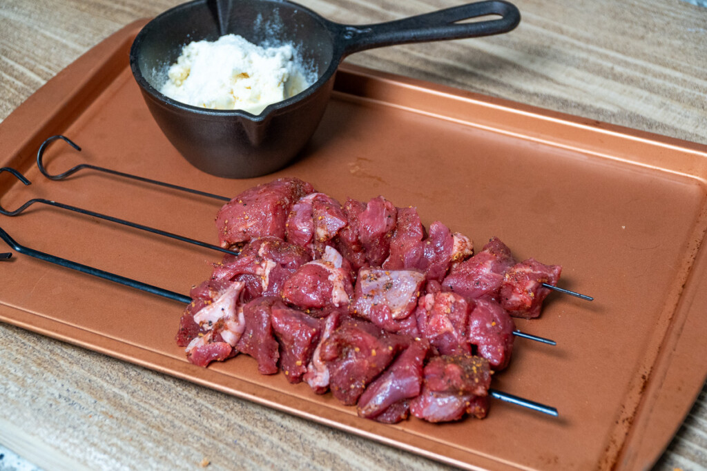 three skewer of raw parmesan steak bites