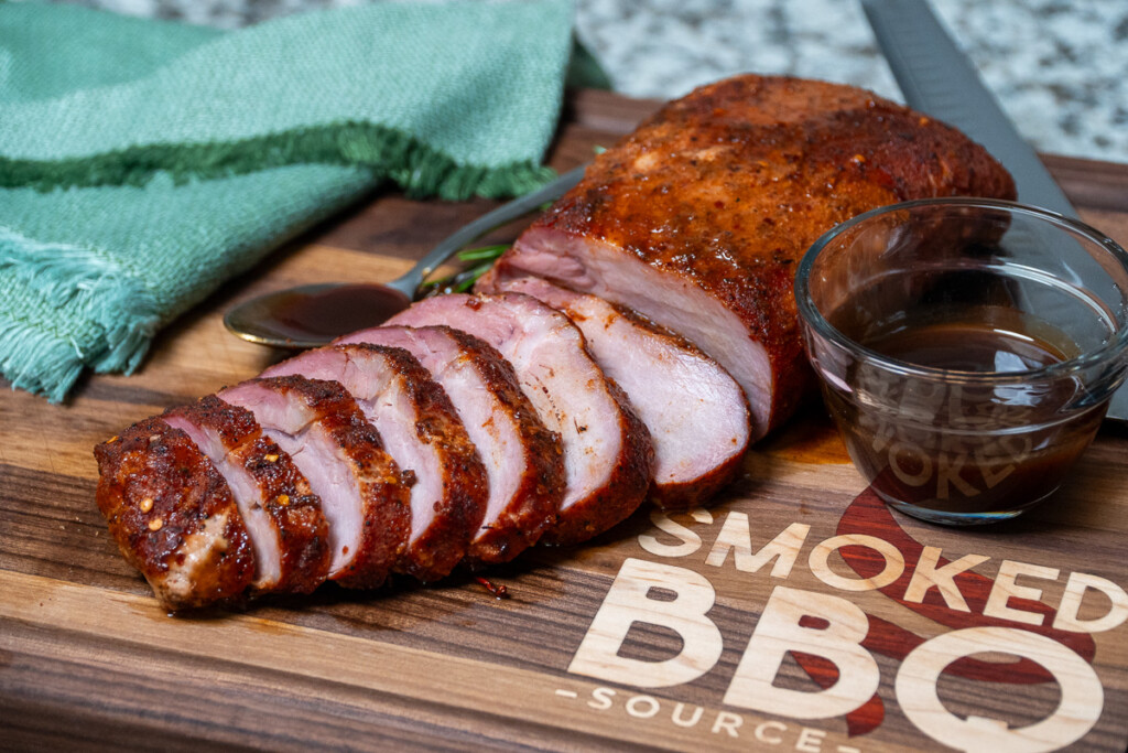 a sliced piece of pork loin on a wooden board