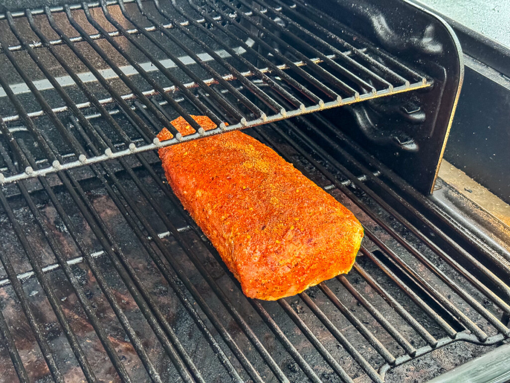 raw seasoned pork loin in the smoker