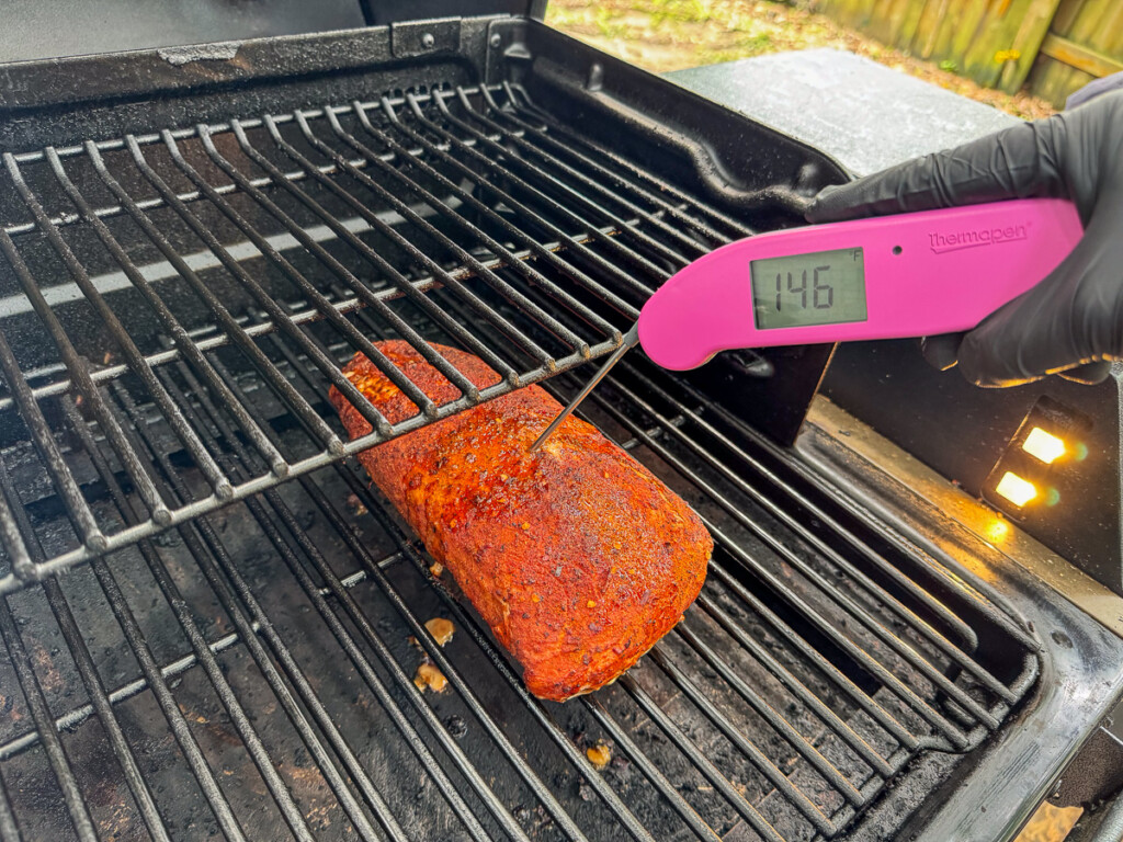 a pork loin in the smoker with an instant read thermometer inserted into it read 145c