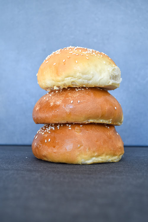 three brioche burger buns stacked on top of each other