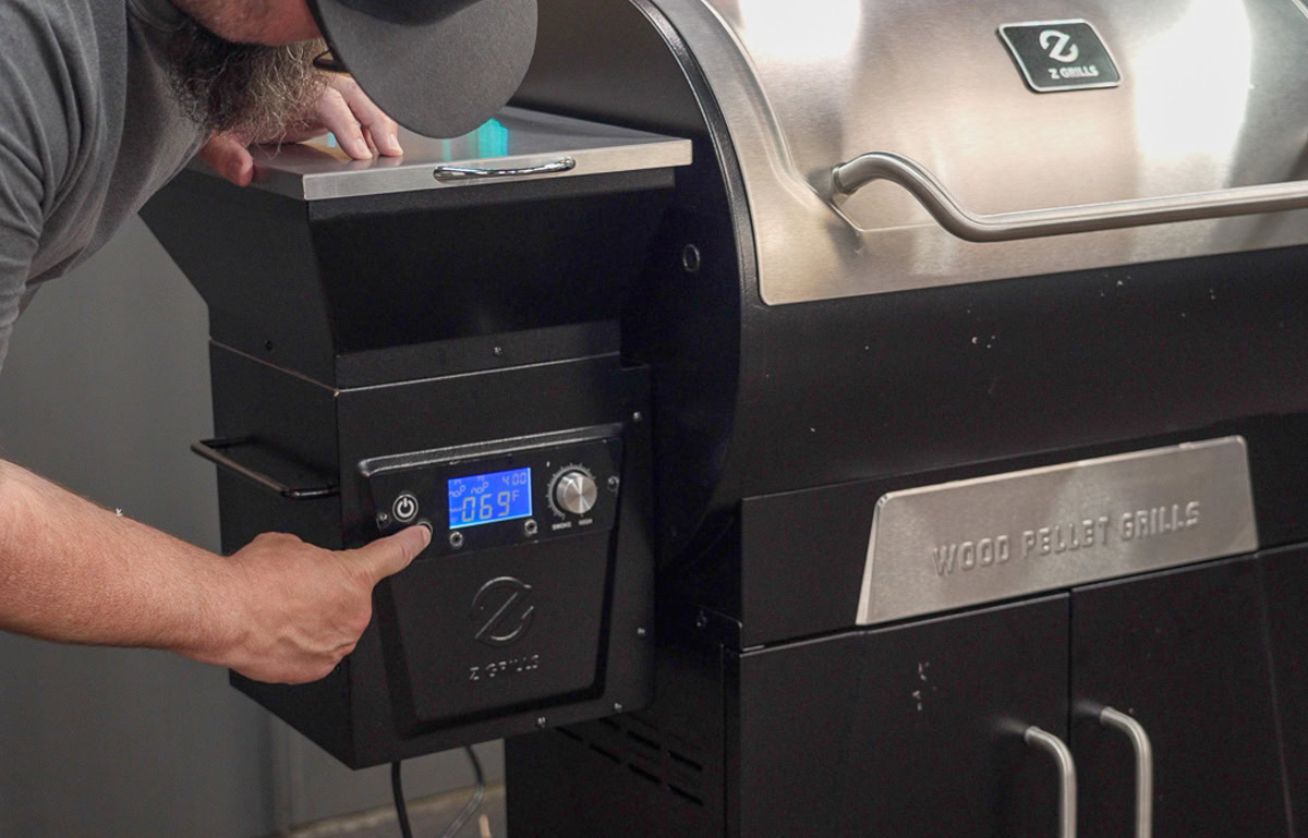 Man pointing to controller on Z Grills pellet smoker