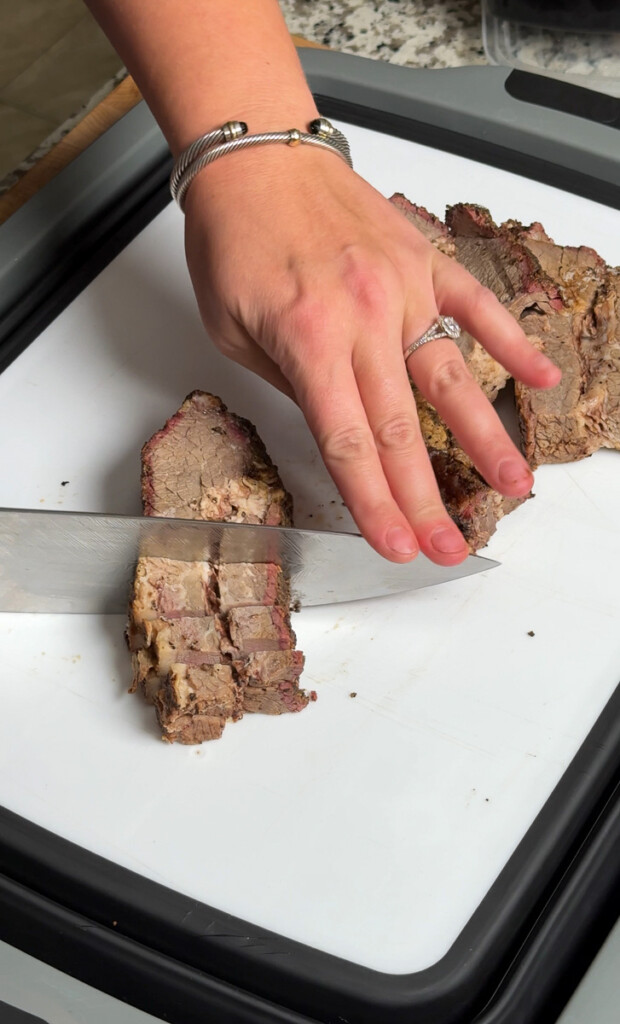 brisket being chopped into cubes on a white board