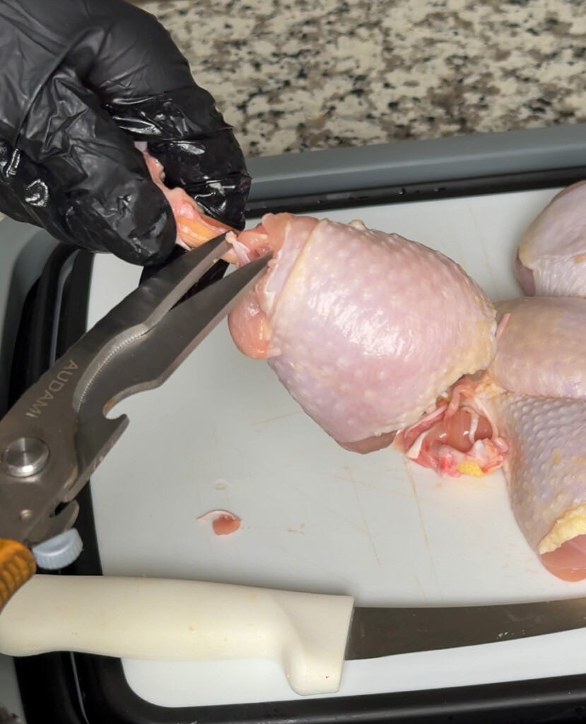 snipping the meat away from the drumstick bone