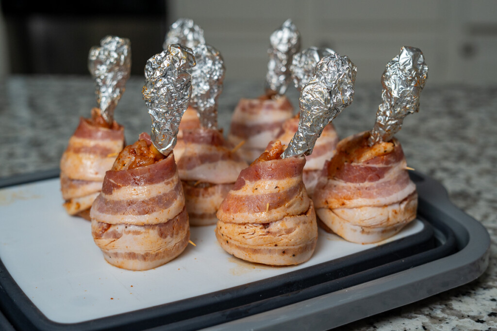 raw chicken lollipops wrapped in bacon and foil tips