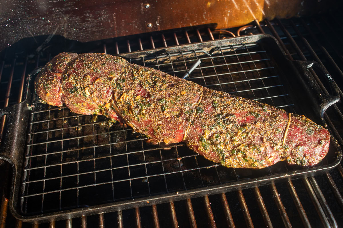 a cooked beef tenderloin on the smoker with a temperature probe sticking out of it