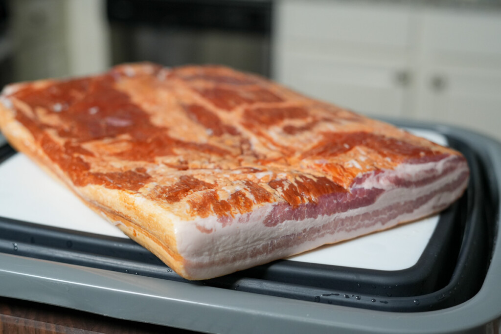 a slab of bacon on a white board